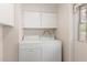 Functional laundry room with white washer and dryer units and overhead storage at 4106 W Mission Ln, Phoenix, AZ 85051