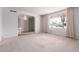 Large, empty living room with carpeted floors and a wide window bathing the space in natural light at 4106 W Mission Ln, Phoenix, AZ 85051