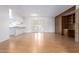 Spacious room with hardwood floors leading to a kitchen and a built-in bookshelf with exposed brick at 4106 W Mission Ln, Phoenix, AZ 85051