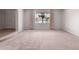 Bright, empty living room with carpeted floors and a view of the neighborhood through a large window at 4106 W Mission Ln, Phoenix, AZ 85051