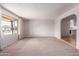 Bright, empty living room with carpet and a large window offering pleasant views at 4106 W Mission Ln, Phoenix, AZ 85051