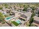 Beautiful aerial view of a home with a pool, manicured lawn, and outdoor living spaces in a vibrant neighborhood at 43612 W Chambers Ct, Maricopa, AZ 85138