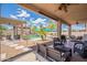 A backyard featuring covered patio with seating area and pool with umbrellas at 43612 W Chambers Ct, Maricopa, AZ 85138