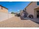 Spacious backyard with a gravel area, patio, outdoor seating, shed, and grill, offering plenty of space for activities at 43612 W Chambers Ct, Maricopa, AZ 85138