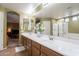Bright bathroom featuring double sinks, a large mirror, and a glass-enclosed shower at 43612 W Chambers Ct, Maricopa, AZ 85138