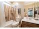 Well-lit bathroom with a wood-look tiled shower, tub, updated fixtures, and a decorative wall print at 43612 W Chambers Ct, Maricopa, AZ 85138