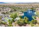 Aerial shot of a community park featuring a lake with fountains, a basketball court, and green spaces at 43612 W Chambers Ct, Maricopa, AZ 85138
