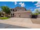Traditional two-story home featuring a three-car garage, well-manicured lawn, and neutral color palette at 43612 W Chambers Ct, Maricopa, AZ 85138