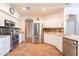 Well-lit kitchen with stainless steel appliances, tile backsplash, and granite countertops at 43612 W Chambers Ct, Maricopa, AZ 85138