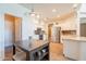 Bright kitchen with white cabinets, stainless steel appliances, and a central island provides ample counter space at 43612 W Chambers Ct, Maricopa, AZ 85138