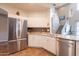 This modern kitchen features stainless steel appliances, granite countertops, and a view of the staircase at 43612 W Chambers Ct, Maricopa, AZ 85138