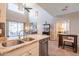 Bright, open-concept kitchen with stainless steel appliances, granite countertops, and high ceilings at 43612 W Chambers Ct, Maricopa, AZ 85138