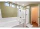 Stylish bathroom with a soaking tub, glass-enclosed shower, and natural light from transom windows at 43612 W Chambers Ct, Maricopa, AZ 85138