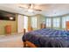 Bedroom features a ceiling fan, barn-style door, and windows with plantation shutters at 43612 W Chambers Ct, Maricopa, AZ 85138