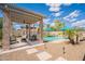 Covered patio with comfortable seating area overlooking the pool and backyard at 43612 W Chambers Ct, Maricopa, AZ 85138
