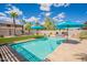 Backyard with a pristine pool, turf, and palm trees under a blue sky at 43612 W Chambers Ct, Maricopa, AZ 85138