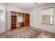 Bonus room with built-in shelving and neutral tile floor covered by a patterned area rug at 4617 W Alicia Dr, Laveen, AZ 85339