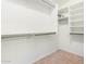 Walk-in closet with shelving and hanging rods, finished with neutral tile flooring at 4617 W Alicia Dr, Laveen, AZ 85339
