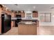 Functional kitchen features wood cabinetry, tile floors, an island, and black appliances at 4617 W Alicia Dr, Laveen, AZ 85339