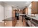 Practical kitchen offers dark countertops, an island, tile flooring, and black appliances at 4617 W Alicia Dr, Laveen, AZ 85339