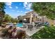Expansive backyard with a pool, fire feature, lush landscaping, and a covered patio with outdoor furniture at 4812 E Daley Ln, Phoenix, AZ 85054