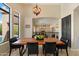 Elegant dining area with a wooden table, black chairs, and a view of the living space at 4812 E Daley Ln, Phoenix, AZ 85054