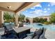 A covered patio featuring elegant seating areas with views of the pristine pool and manicured landscaping at 4812 E Daley Ln, Phoenix, AZ 85054