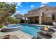 Backyard oasis with a pool, hot tub, fire bowls, and covered patio for entertaining and relaxing at 4812 E Daley Ln, Phoenix, AZ 85054
