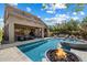 Luxurious pool and hot tub area featuring a fire bowl, covered patio, and views of the lush backyard at 4812 E Daley Ln, Phoenix, AZ 85054