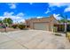 Front exterior shot showing driveway, garage, and a decorative iron gate entrance at 5004 W Kaler Dr, Glendale, AZ 85301