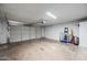 The garage has neutral walls, a roll-up door, and concrete flooring at 5004 W Kaler Dr, Glendale, AZ 85301