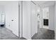 Bright hallway with carpet, white doors, and view into bathroom and bedroom creating a cohesive and clean aesthetic at 5004 W Kaler Dr, Glendale, AZ 85301
