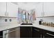 Kitchen corner view shows black sink, quartz counters, window and white cabinets at 5004 W Kaler Dr, Glendale, AZ 85301