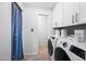 A laundry room featuring new white appliances and white cabinets at 5004 W Kaler Dr, Glendale, AZ 85301