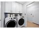 A laundry room featuring new white appliances and white cabinets at 5004 W Kaler Dr, Glendale, AZ 85301
