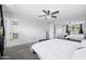 Bright bedroom with a ceiling fan, large mirrored closet, and a comfortable bed by the window at 5004 W Kaler Dr, Glendale, AZ 85301