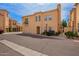 Beige two-story condo featuring a balcony, shuttered windows, and a quaint chimney against a blue sky backdrop at 5015 E Cheyenne Dr # 31, Phoenix, AZ 85044
