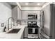This updated kitchen features modern appliances, light gray cabinetry, quartz countertops, and stylish backsplash at 5015 E Cheyenne Dr # 31, Phoenix, AZ 85044