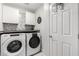 Clean laundry room features white appliances, cabinets, and a decorative tile backsplash at 5015 E Cheyenne Dr # 31, Phoenix, AZ 85044