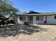 Modest home featuring a low, gabled roof and a gravel front yard against a bright, clear blue sky at 520 W Mcneil St, Phoenix, AZ 85041