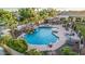 Aerial view of the luxurious custom backyard with pool, slide, waterfall, spa, and covered patio with lounge seating at 5511 N 128Th Dr, Litchfield Park, AZ 85340