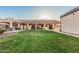 A well-manicured lawn with a covered patio and outdoor kitchen offer luxurious outdoor living at 5511 N 128Th Dr, Litchfield Park, AZ 85340