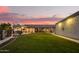 Expansive backyard featuring a covered patio, outdoor kitchen, and green lawn at 5511 N 128Th Dr, Litchfield Park, AZ 85340