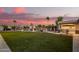 Expansive backyard with green lawn, outdoor kitchen and grill, and pool area at 5511 N 128Th Dr, Litchfield Park, AZ 85340