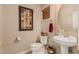 Powder room with a pedestal sink, artwork, wood blinds and a bronze mirror at 5511 N 128Th Dr, Litchfield Park, AZ 85340