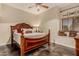 Bedroom with a wooden bed frame, dark floors, and a cozy window seat with decorative pillows at 5511 N 128Th Dr, Litchfield Park, AZ 85340