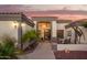 Charming front entrance with arched doorway, chandelier, and patio table set at 5511 N 128Th Dr, Litchfield Park, AZ 85340