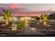 Charming home featuring desert landscaping with beautiful palm trees and a well-lit walkway at 5511 N 128Th Dr, Litchfield Park, AZ 85340