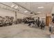 Spacious garage featuring ample storage, gym equipment, and space for a motorcycle and boat at 5511 N 128Th Dr, Litchfield Park, AZ 85340