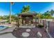 The relaxing backyard is complete with a shaded pergola, rock and paver details, and desert landscaping at 5511 N 128Th Dr, Litchfield Park, AZ 85340